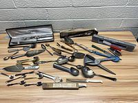 Overall view of assorted vintage silverware and flatware laid out on a table including knives, spoons, forks, and other specialty utensils