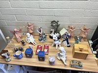 Overview of the lot showing various angel figurines, ceramic and glass items on table.