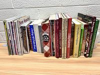 Wide view of the cookbooks and cooking magazines arranged standing upright, showing various titles and conditions.