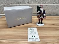 Lenox box, collector's card, and figurine displayed on wood surface.