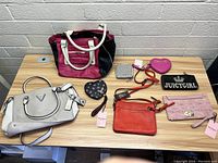 View of all 8 purses and wallets on table, showing size, colors, and designs.