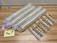 Overview of lot showing bundles of clear 4 oz cups on left and sealed packs of 1 oz cups on right with 4 oz label