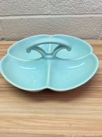 Front view of the blue ceramic divided serving dish with three sections and central handle.