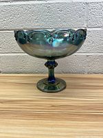Front view of vintage iridescent glass bowl on pedestal, showing scalloped rim and iridescent sheen.