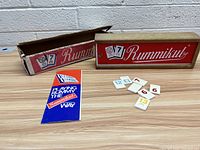Vintage Rummikub game box, white plastic tiles with colored numbers, and blue rule booklet