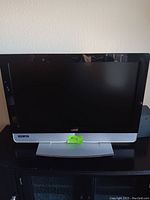 Front view of a 32 inch Vizio TV on a black surface showing the full screen and stand.