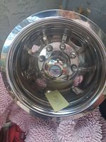 Front view of chrome truck wheel with reflective surface and visible bolt holes, showing condition and branding on center cap.