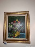 Framed original oil painting hanging on wall showing floral bouquet with tulips and lilacs.