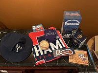 Full overview of items including bobblehead box, replica ring box, baseball, hat, towel, magnet, pin, koozie