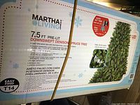 Close-up of the box label indicating the brand, model, dimensions, lighting features, and specifications of the pre-lit artificial Christmas tree.