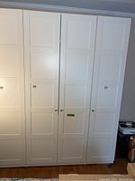 Front view of three-door white cabinet closed