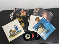 Collection of various used vinyl LP records and four 45 RPM singles with covers visible including Kenny Rogers, Neil Diamond, ABBA and others.