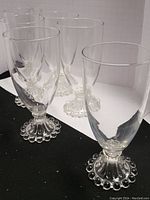 Close-up view of several clear wine glasses with Candlewick bubble detail on stems.