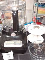 Wolfgang Puck Bistro food processor base with clear plastic bowl and attachments removed.