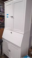 Front view showing full white secretary desk cabinet with closed doors and drop front closed.