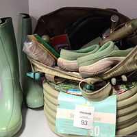 Photo of the full garden supplies lot showing coiled garden hose, rubber boots, Merrell clogs, and gardening tote with tools.
