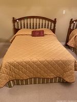 Full view of double bed with headboard, bedcover, pillow, and dust ruffle