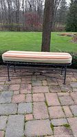 Iron bench with ornate metalwork base, black, outdoor patio setting