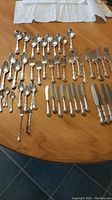 Overall arrangement of flatware items on wooden table