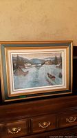 Full view of framed pastel landscape on dresser