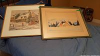 Two framed watercolour paintings on blue cloth