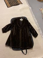 Full view of coat laid flat on garment bag