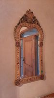 Front view of the wall mirror showing full frame and reflection of door.