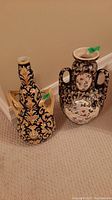 Both floor vases side by side on carpeted floor against wall