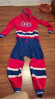 Full view of the Montreal Canadiens onesie pajama laid flat, showing front with logo and color pattern