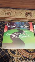Front cover of Lynyrd Skynyrd's "One More From The Road" vinyl record, showing green road design and title text.
