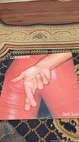 Loverboy Get Lucky album cover featuring a close-up of crossed fingers wearing red pants on a carpet background.