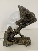 Side view of chameleon lamp showing detailed metal texture and glass lampshade