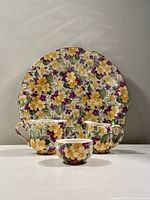 Full set image showing one plate, one cup, one creamer, and one sugar bowl with floral chintz pattern