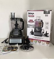 Full view of the Ninja food processor, attachments, manuals and original box.