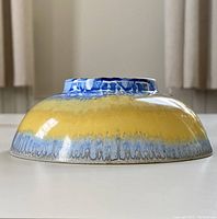 Side view of Shelley drip ware bowl showing yellow to blue glaze drip effect.