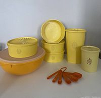 Photo of all seven canisters and five amber measuring spoons showing colors, sizes, and floral details.