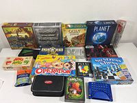 Photo showing array of board games and puzzles including Catan versions, Monopoly Mandalorian, No Stress Chess, Operation, Quoits, and others.