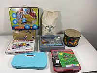 Overview of all items included in the lot arranged on a white table showing the full variety of toys and kits.