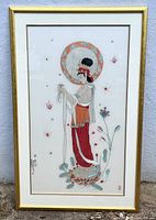 Full view of the framed silk embroidery art hung on a wall, showing the entire image of a traditionally dressed woman in profile with elaborate embroidery details.