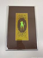 Full view of the framed artwork showing the print centered with silver frame and brown mat.