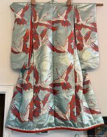 Front view of the blue-green silk uchikake with crane motifs, laid out and held up to show full pattern and shape.