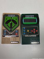 Top view of two handheld electronic games, Mattel Electronics Baseball (tan) and Football 2 (dark green) from 1978 showing front controls, buttons and screen graphics.