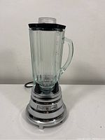 Full view of the Waring blender with ribbed glass pitcher on chrome base, cord visible.
