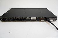 Rear view of Dolby SDU4 rack unit showing XLR input/output connectors, serial and model labels, and power cord connection.