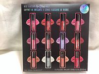 Front view of boxed 12-piece Kiss Glossary Lip Gloss Vault set showing all lip gloss tubes and packaging details.