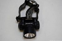 Top view of the Pelican HeadsUP Lite headlamp including the elastic adjustable head strap that has Pelican branding on it.