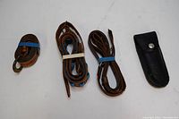 Top view showing rolled leather belts and black cutter case.