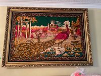 Full view of large framed fabric artwork featuring the central peacock scene in an ornate gold frame.