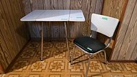 Side view of retro double drop leaf Formica table with vintage chair, showing table folded and unfolded with chair beside.