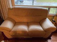 Front view of two-seat leather sofa showing overall condition and structure